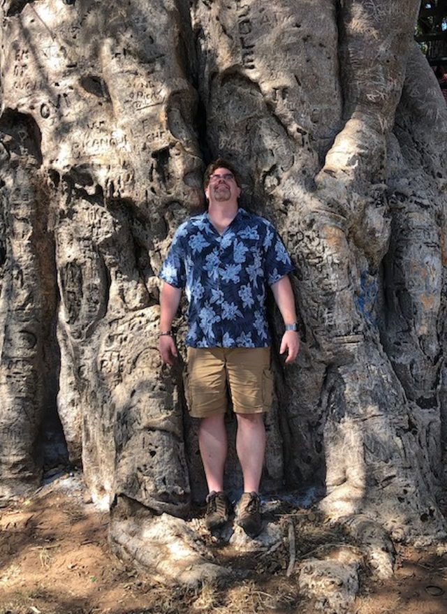 Scott standing under a large tree.